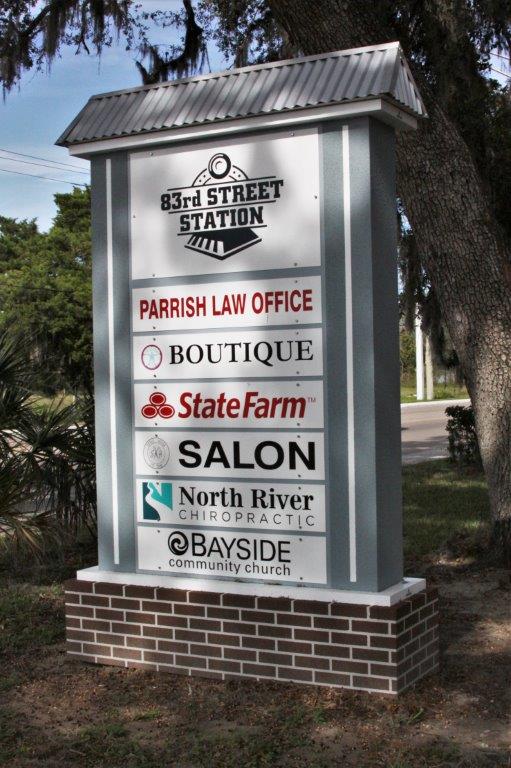 Pylon shopping center sign with a State Farm Sign