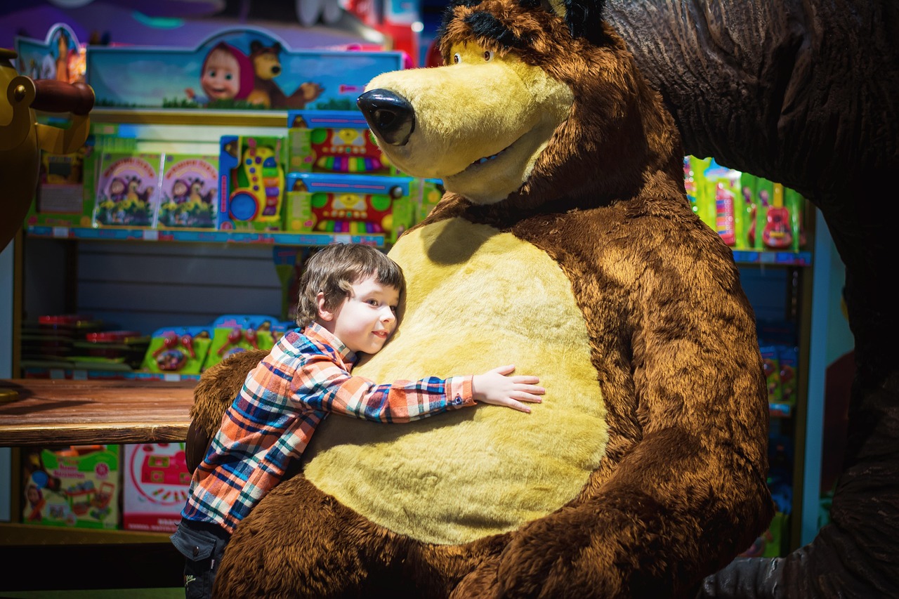 boy hugging bear in a toy store - Toy Store Signs page